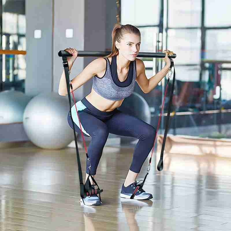 Kobieta ćwicząca z drążkiem do pilatesu