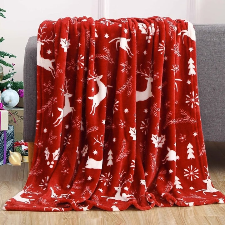Świąteczny koc flanelowy z reniferami na kanapie
